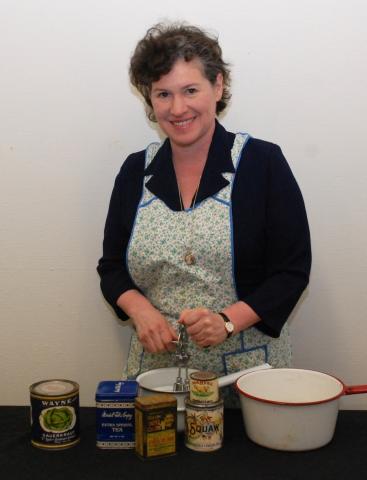 Presenter Ellie in 1930s garb mixing ingredients in a cooking pot